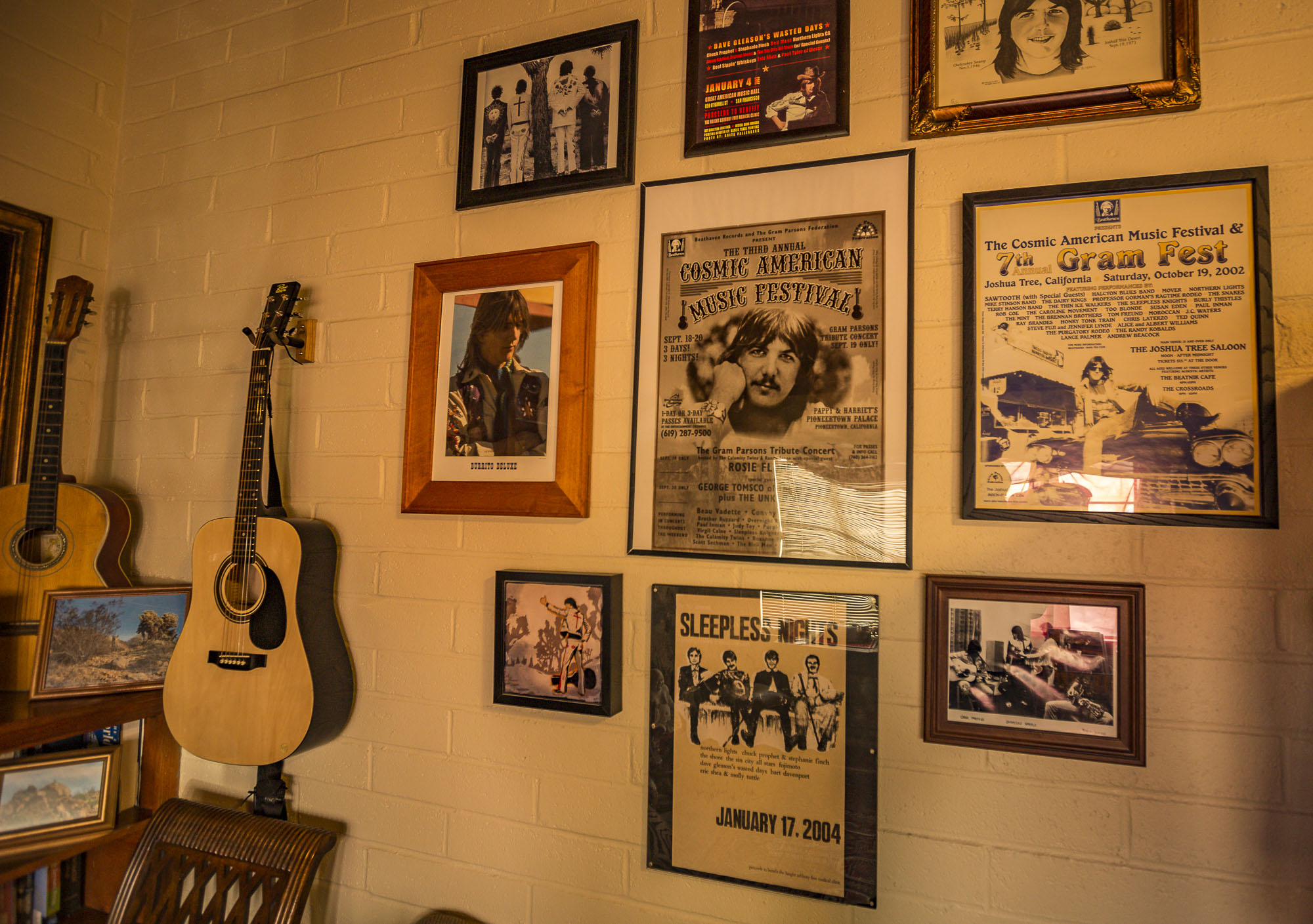 a wall with photos of various musical events featuring Gram Parsons 